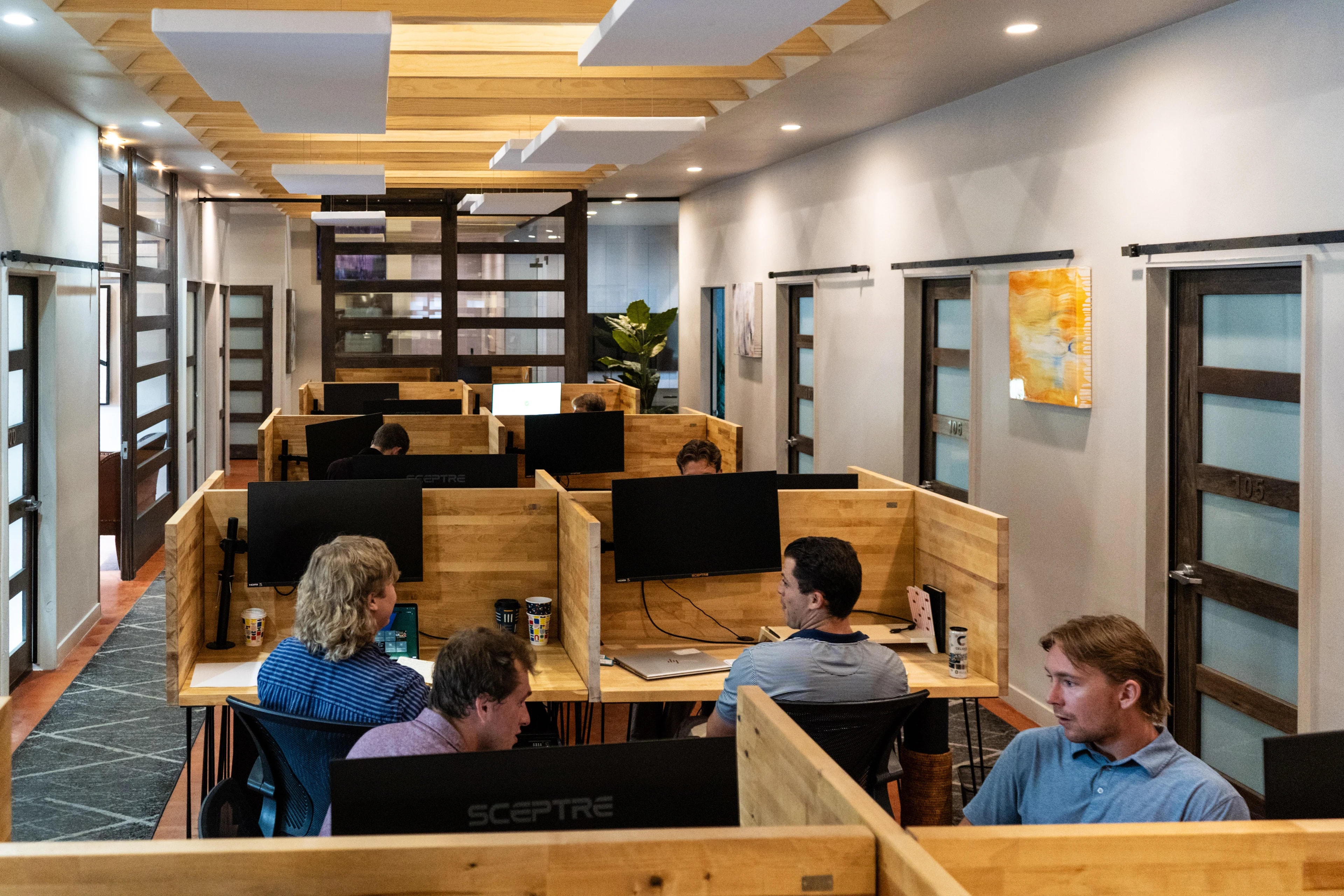 Members at work in the butcher block desk pods at Merritt Workspace, a coworking space in Sloan's Lake, Denver